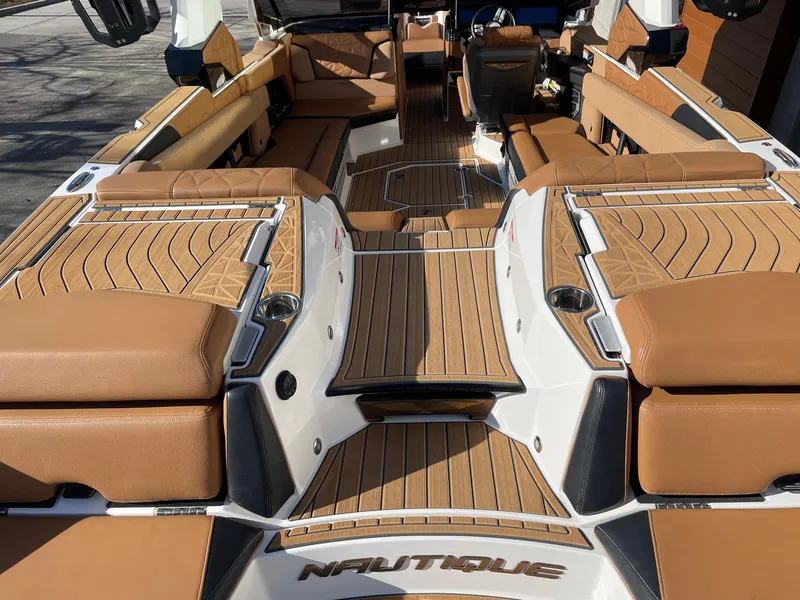 Slide: The Image of 2023 Nautique Super Air Nautique G25 Paragon interior with luxurious tan seating and teak flooring. - 4
