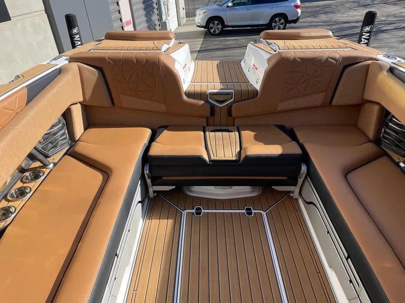 Slide: The Image of 2023 Nautique Super Air Nautique G25 Paragon interior with tan seating and teak flooring. - 8