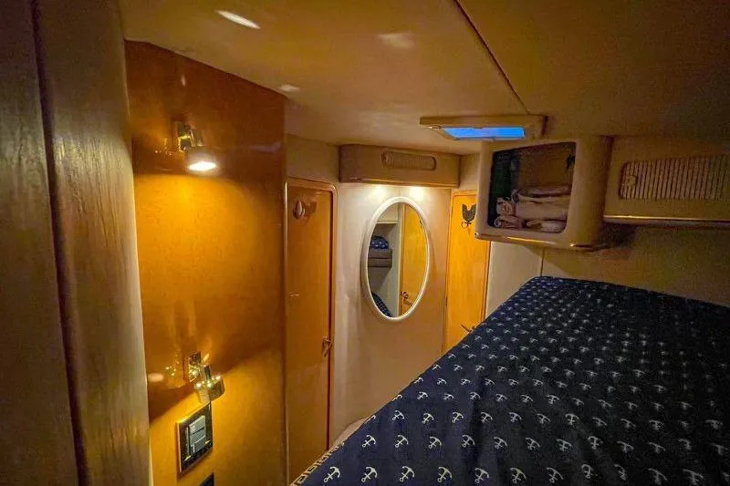 Slide: The Image of 1998 Sea Ray 500 Sundancer cabin interior with cozy lighting and nautical-themed bedding. - 17