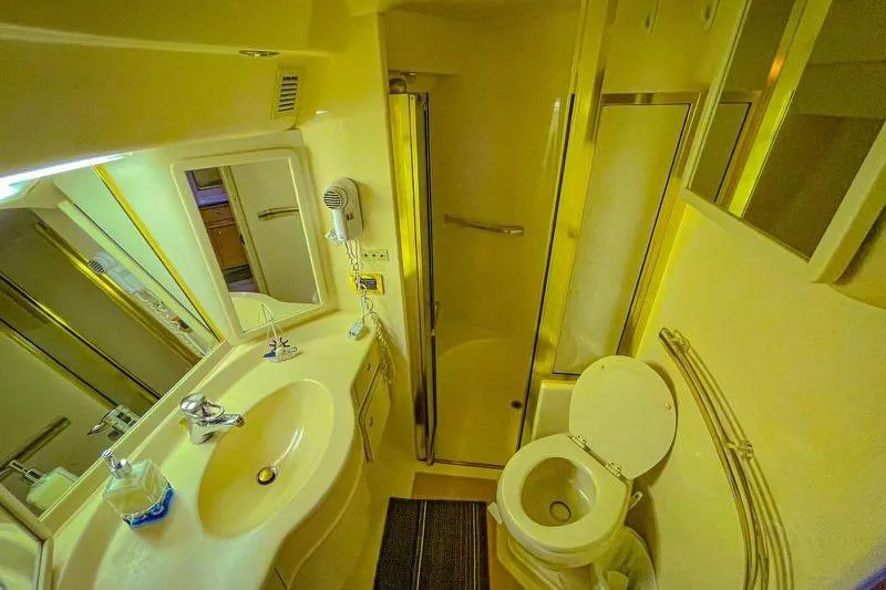 Slide: The Image of Bathroom interior of 1998 Sea Ray 500 Sundancer yacht, featuring sink, toilet, and shower. - 19
