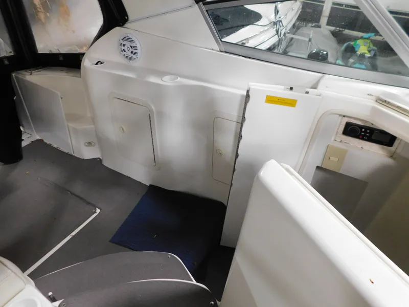 Slide: The Image of Interior view of a 1998 Cruisers 2870 Rogue boat, featuring white seating and storage compartments. - 12