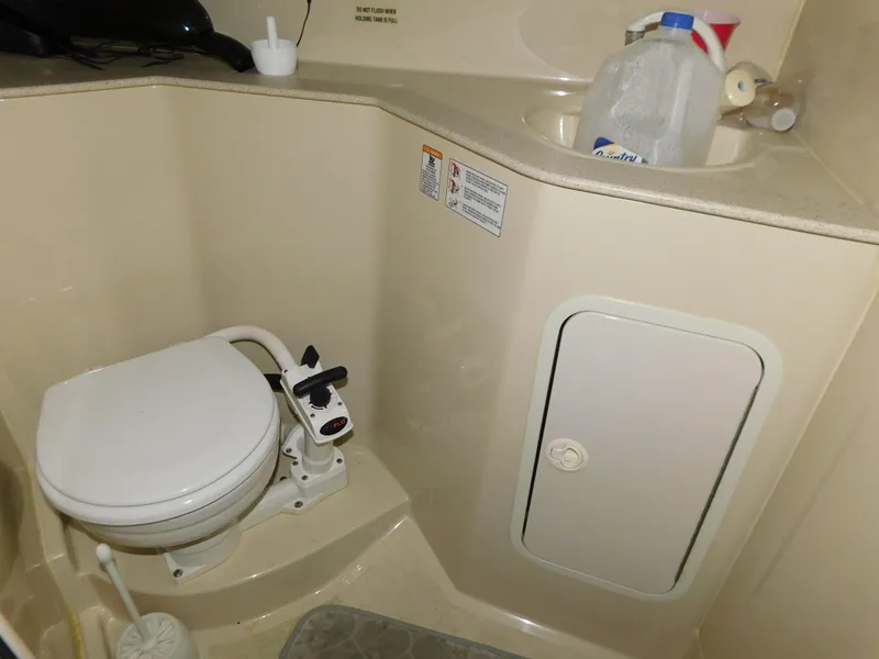 Slide: The Image of 1998 Cruisers 2870 Rogue boat bathroom with toilet, sink, and storage compartment. - 25