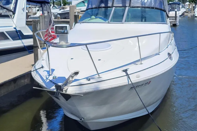 The Image of 1998 Cruisers 2870 Rogue boat docked in marina, featuring sleek design and white exterior. - 1