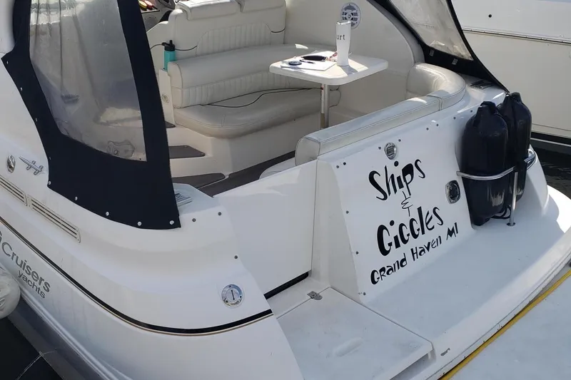 Slide: The Image of 1998 Cruisers 2870 Rogue boat with "Ships & Giggles" sign, docked at Grand Haven, MI. - 3