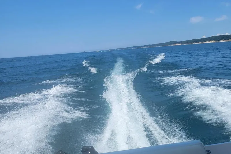 Slide: The Image of Wake of a 1998 Cruisers 2870 Rogue boat on open water under a clear blue sky. - 4