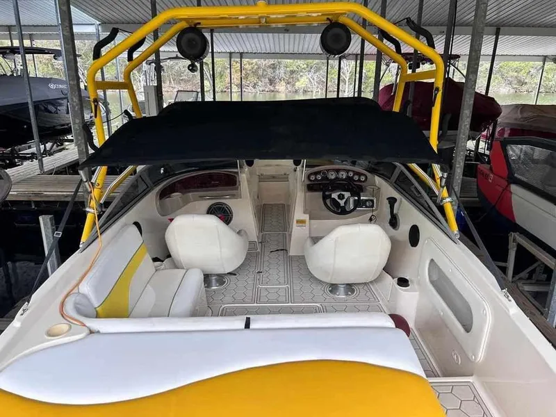 Slide: The Image of 2003 Rinker RX1 boat interior with yellow accents and dual seating. - 10