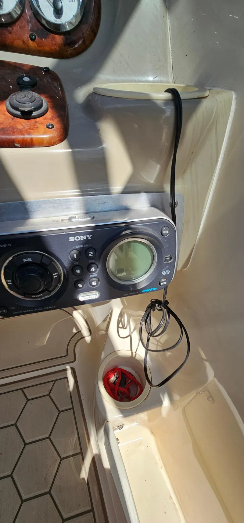 Slide: The Image of 2003 Rinker RX1 boat dashboard with Sony stereo system and nautical controls. - 16