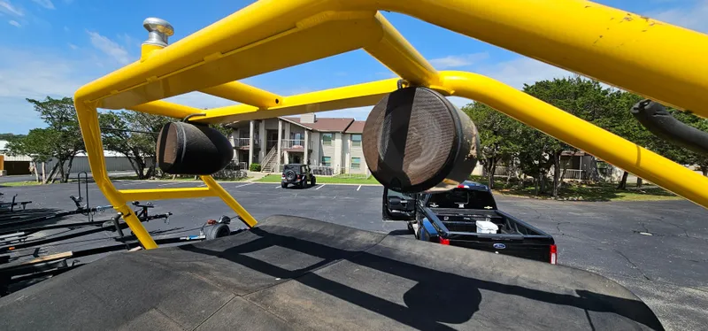 Slide: The Image of Yellow frame on 2003 Rinker RX1 boat with speakers, parked near apartments. - 17