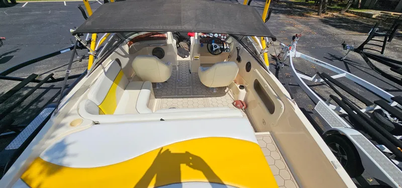 Slide: The Image of 2003 Rinker RX1 boat interior with yellow and white seating, parked on a trailer. - 18