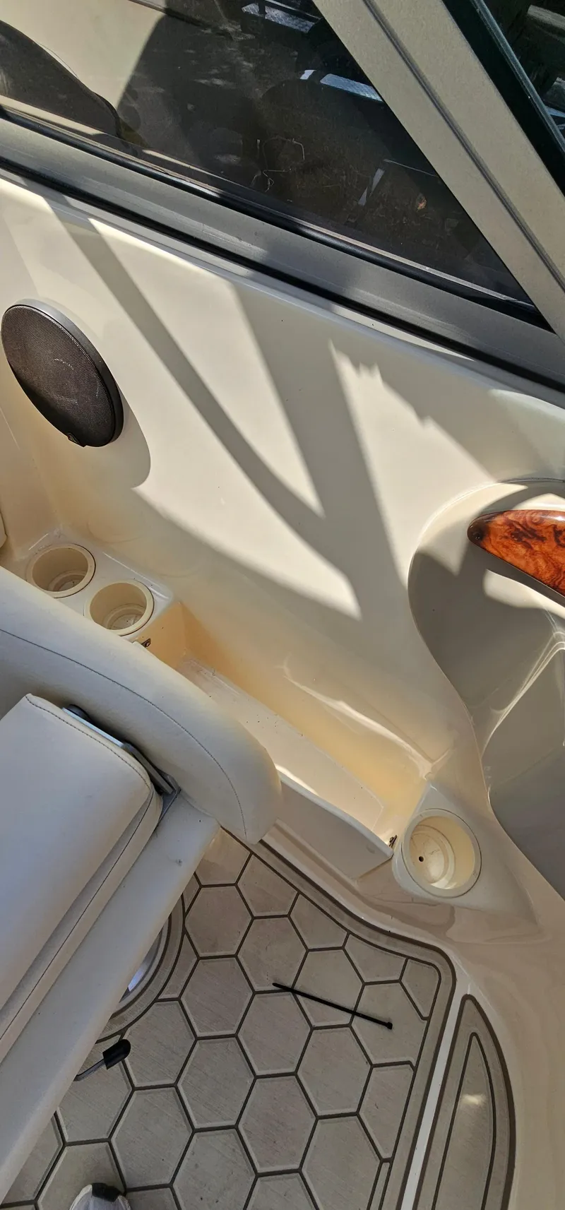 Slide: The Image of 2003 Rinker RX1 boat interior with speaker, cup holders, and hexagonal floor pattern. - 20
