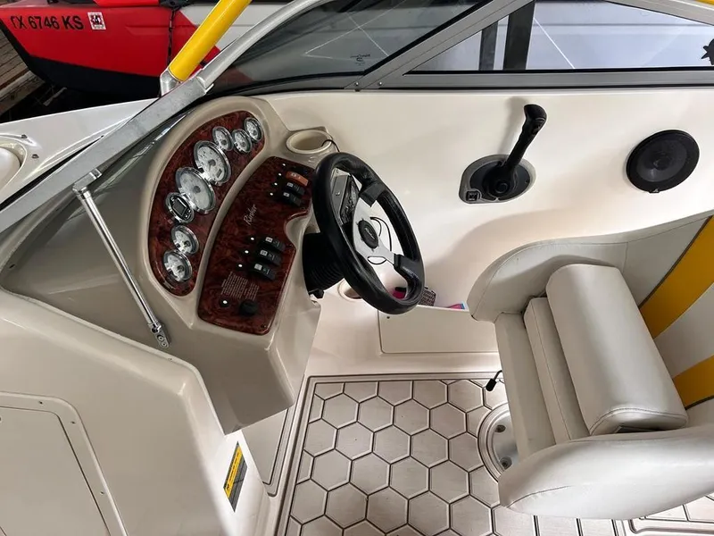 Slide: The Image of 2003 Rinker RX1 boat cockpit with steering wheel and control panel. - 6