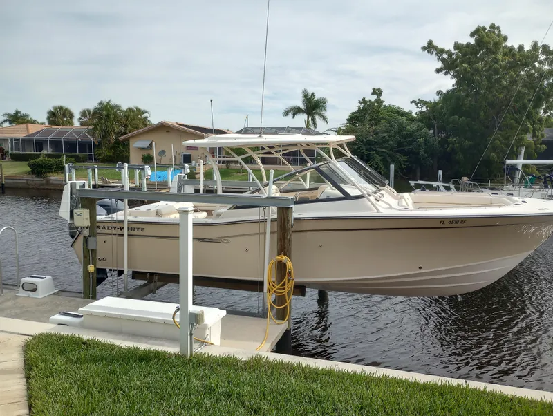 Slide: The Image of 2016 Grady-White Freedom 307 boat interior with white leather seating and steering wheel. - 8