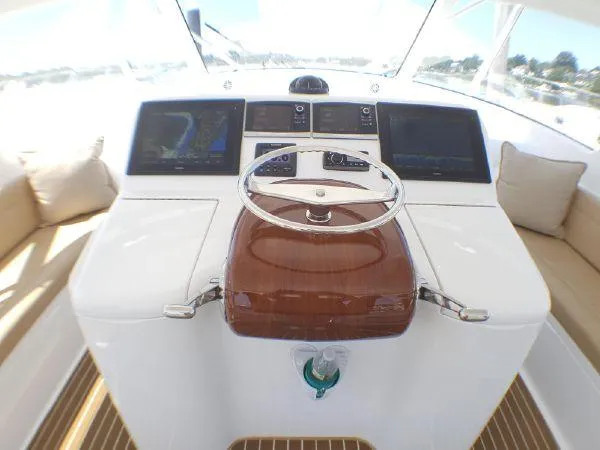 Slide: The Image of 2016 Viking 42 Open yacht helm with modern navigation displays and wooden steering wheel. - 2
