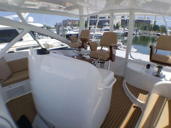 Slide: The Image of 2016 Viking 42 Open yacht interior with helm chairs and marina view. - 5