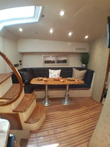 Slide: The Image of 2016 Viking 42 Open yacht interior with dining area and wooden flooring. - 6