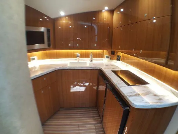 Slide: The Image of Luxurious 2016 Viking 42 Open yacht kitchen with modern appliances and wood cabinetry. - 9
