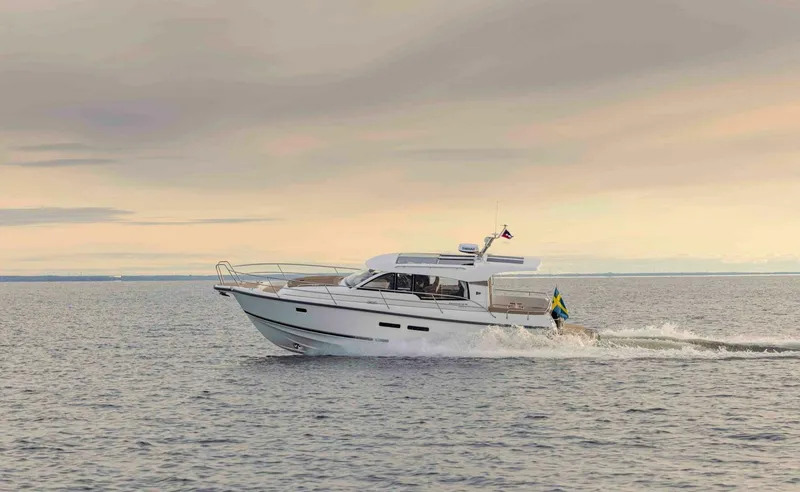 Slide: The Image of Nimbus 365 Coupe 2025 cruising on calm waters at sunset. - 1