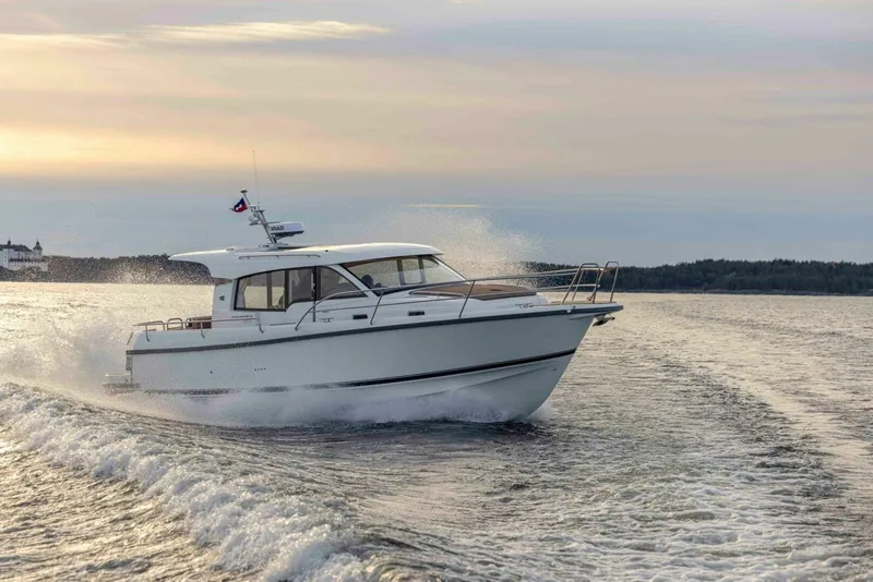 Slide: The Image of Nimbus 365 Coupe 2025 cruising on open water at sunset. - 2