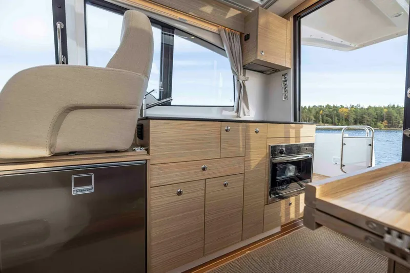 Slide: The Image of Interior of 2025 Nimbus 365 Coupe boat with modern kitchen and scenic water view. - 8