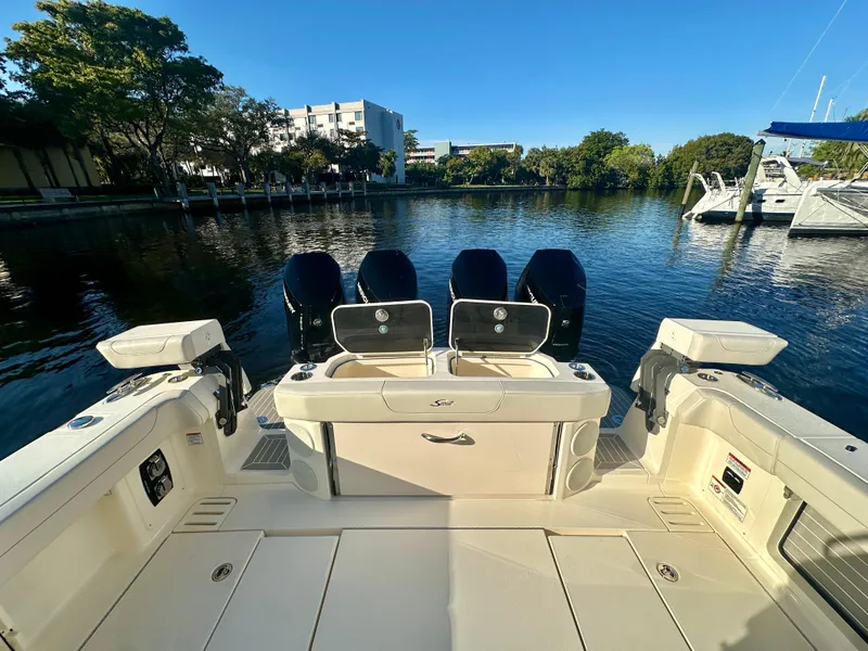 Slide: The Image of 2025 Scout 425 LXF boat with four engines docked by a serene waterfront. - 10