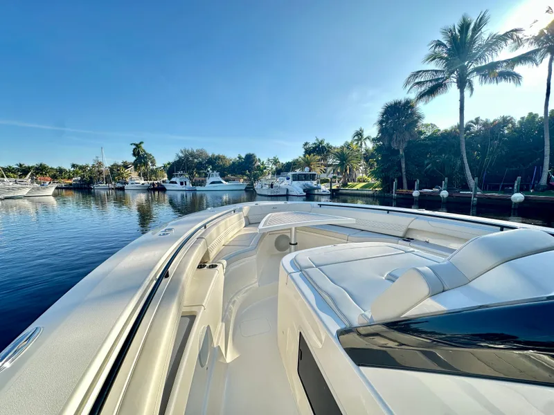 Slide: The Image of 2025 Scout 425 LXF boat docked in a scenic marina with palm trees. - 12