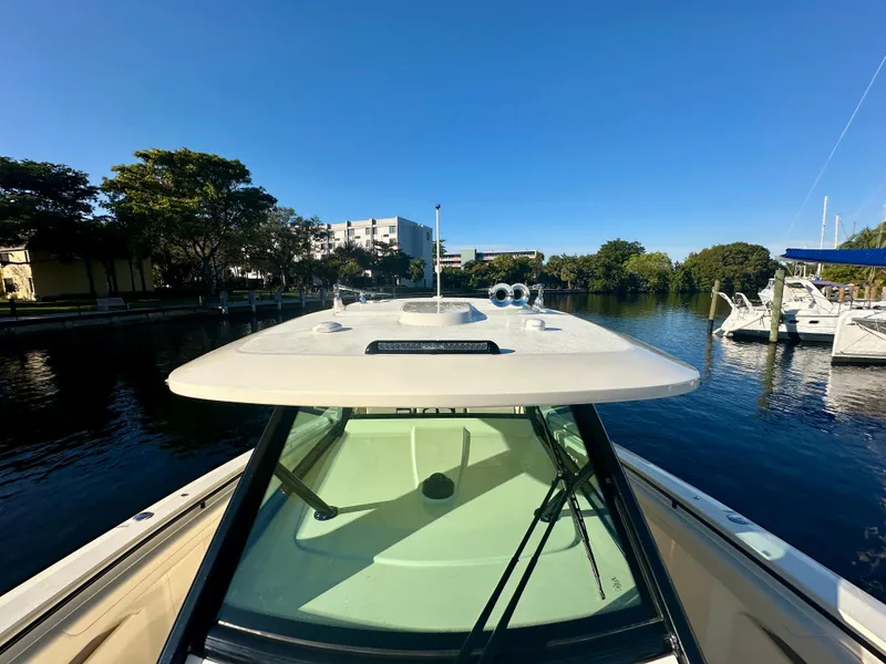 Slide: The Image of 2025 Scout 425 LXF boat docked in a serene marina setting. - 15