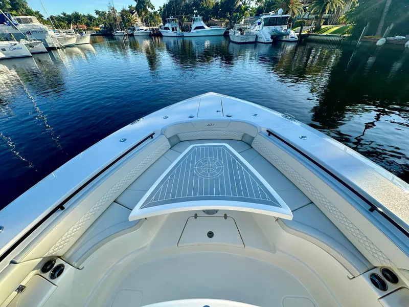 Slide: The Image of 2025 Scout 425 LXF boat bow view in a serene marina setting. - 16