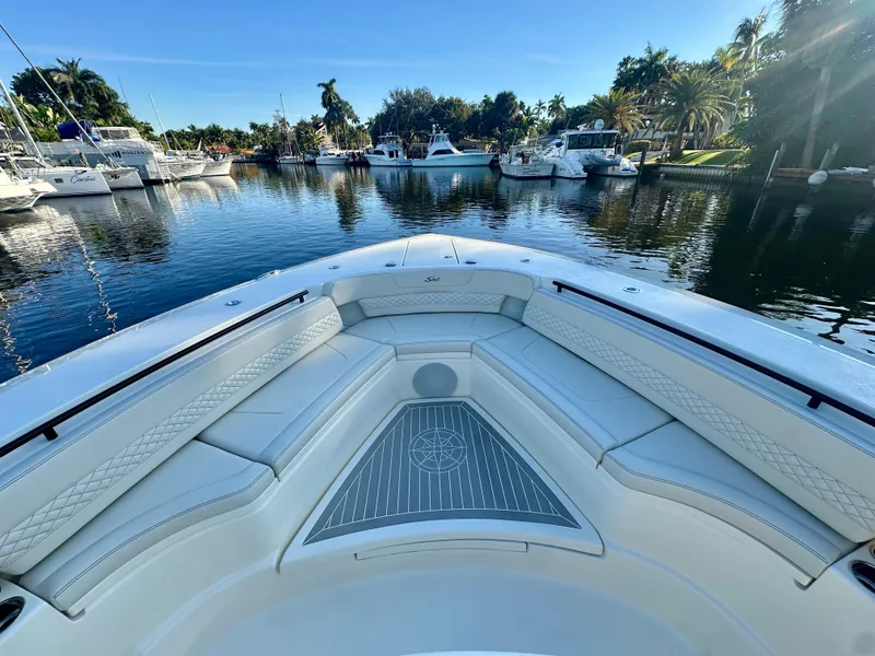 Slide: The Image of 2025 Scout 425 LXF boat interior with luxurious seating in a scenic marina. - 17