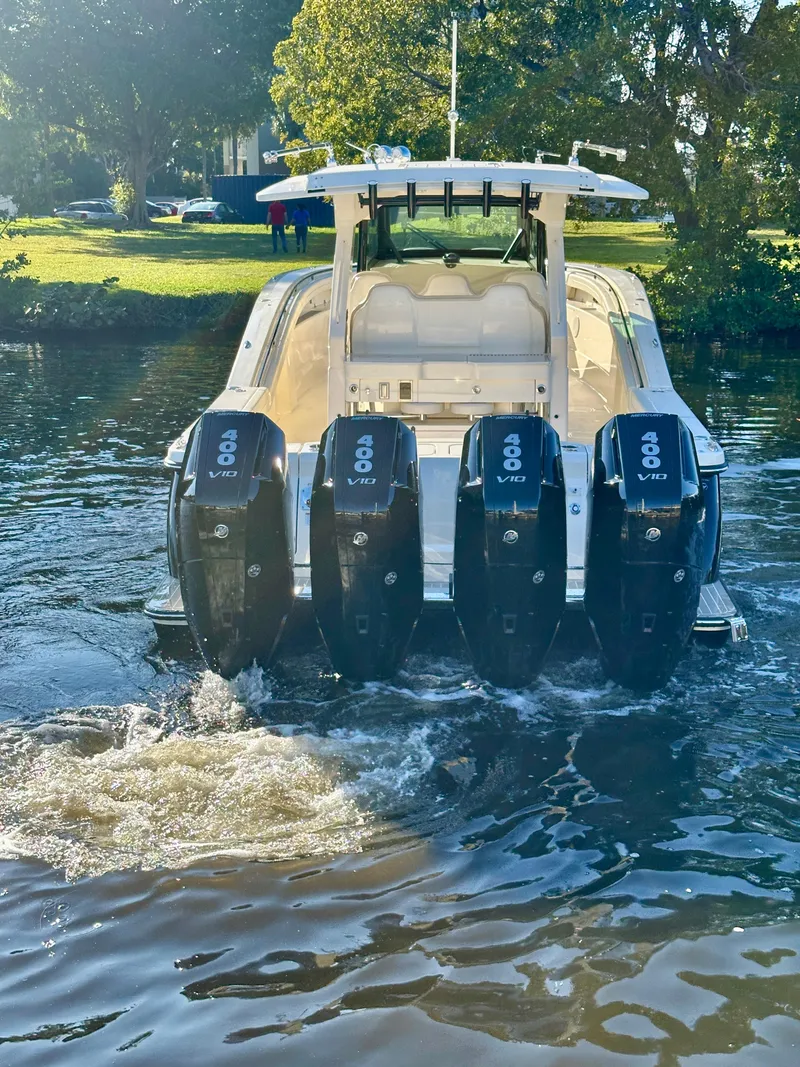 Slide: The Image of 2025 Scout 425 LXF boat with four powerful outboard engines on a sunny day. - 2