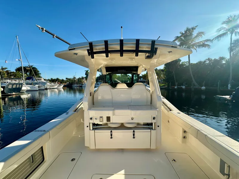 Slide: The Image of 2025 Scout 425 LXF boat interior with seating, docked by palm trees. - 21