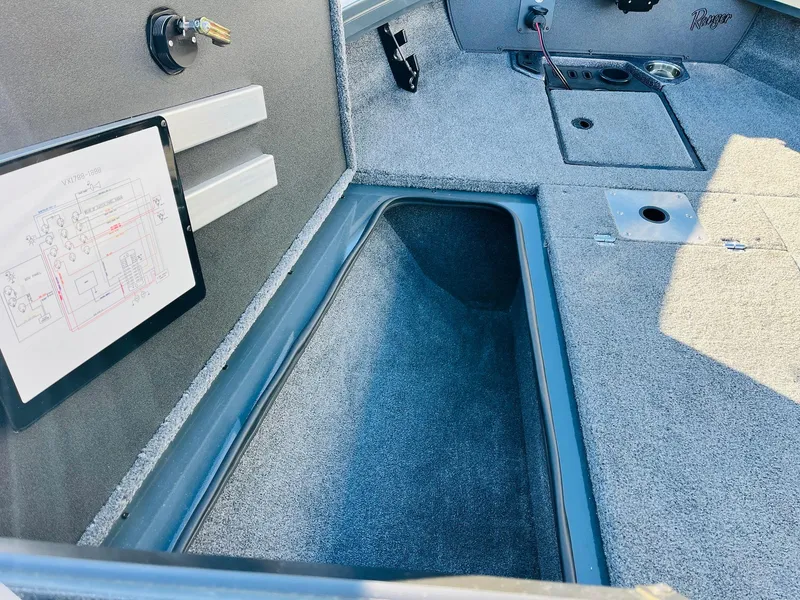 Slide: The Image of Interior of 2025 Ranger VX1988 WT boat showing storage compartment and control panel. - 19