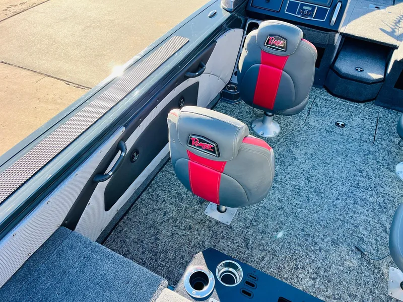 Slide: The Image of 2025 Ranger VX1988 WT boat interior with red and gray seating, carpeted floor, and cup holders. - 41