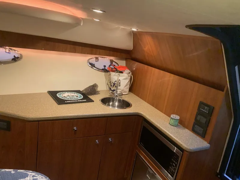 Slide: The Image of Interior of 2012 Tiara Yachts 3100 Coronet with kitchenette and wood finish. - 12