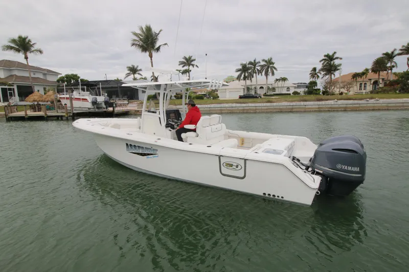 Slide: The Image of 2016 Sea Hunt Gamefish 30 boat on water, palm trees in background. - 1