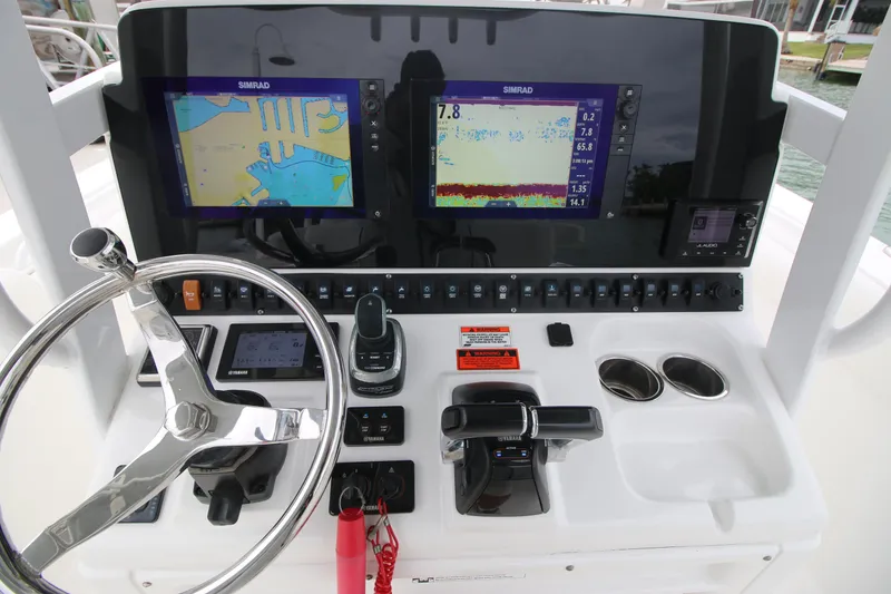 Slide: The Image of 2016 Sea Hunt Gamefish 30 dashboard with navigation screens and steering wheel. - 10