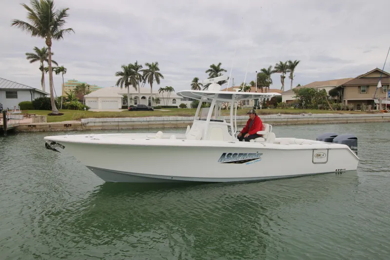Slide: The Image of 2016 Sea Hunt Gamefish 30 boat on water, palm trees in background. - 2