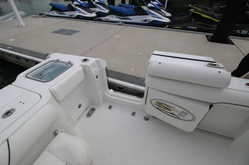 Slide: The Image of 2016 Sea Hunt Gamefish 30 boat interior near dock with jet skis in background. - 24
