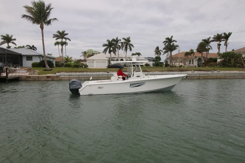 Slide: The Image of 2016 Sea Hunt Gamefish 30 boat cruising in a tropical canal with palm trees. - 3