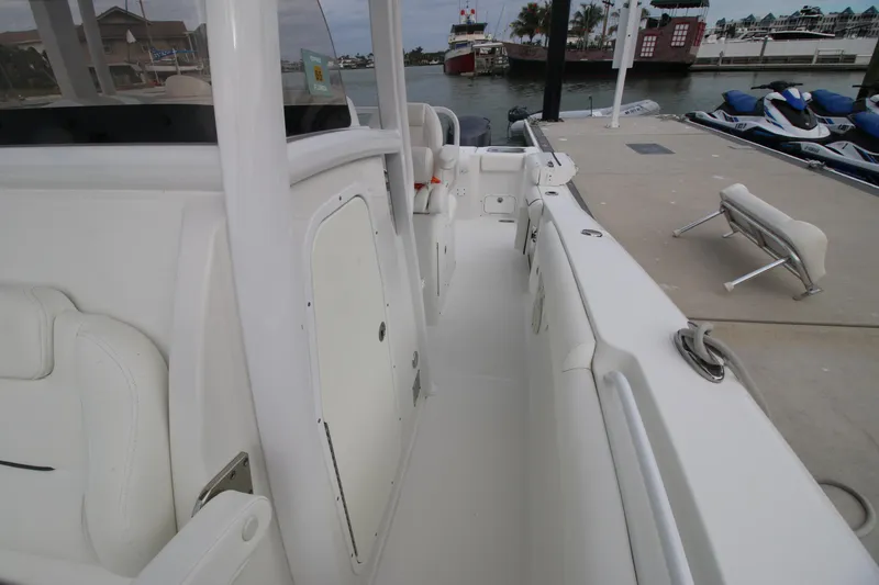 Slide: The Image of 2016 Sea Hunt Gamefish 30 boat docked, showcasing spacious deck and seating area. - 33