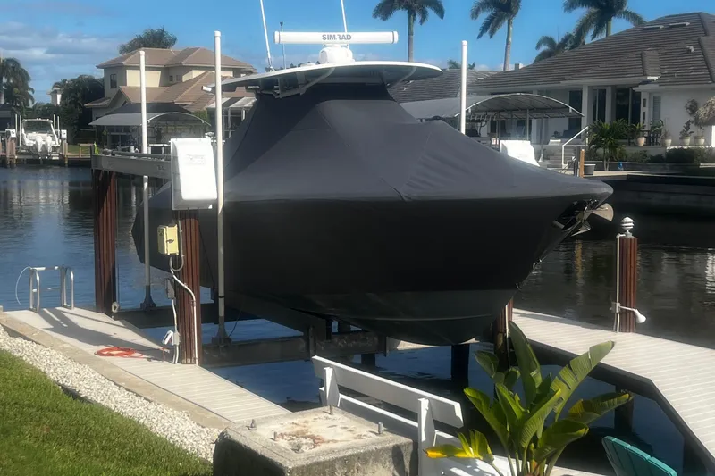 Slide: The Image of 2016 Sea Hunt Gamefish 30 boat covered and docked by waterfront homes. - 40