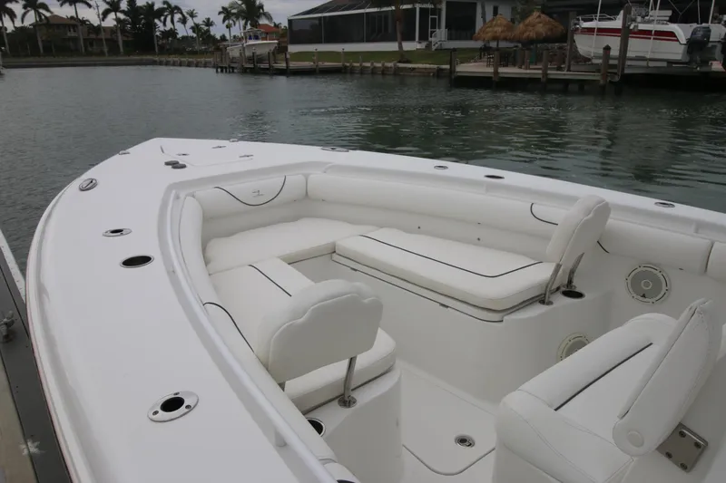 Slide: The Image of 2016 Sea Hunt Gamefish 30 boat with white seating, docked by calm waters. - 5