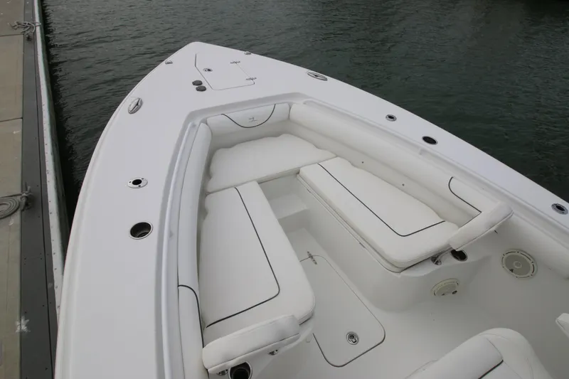 Slide: The Image of 2016 Sea Hunt Gamefish 30 boat with white cushioned seating, docked by the water. - 6