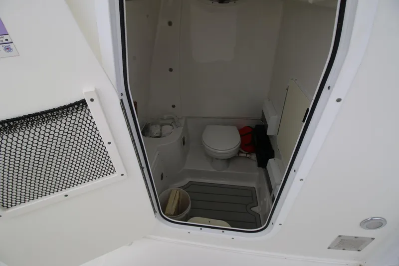 Slide: The Image of Interior of 2016 Sea Hunt Gamefish 30 boat showing compact bathroom with toilet. - 9