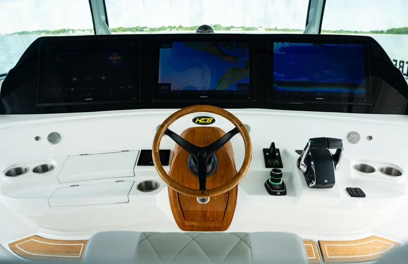 Slide: The Image of 2023 HCB 65 Estrella helm with advanced navigation displays and wooden steering wheel. - 15