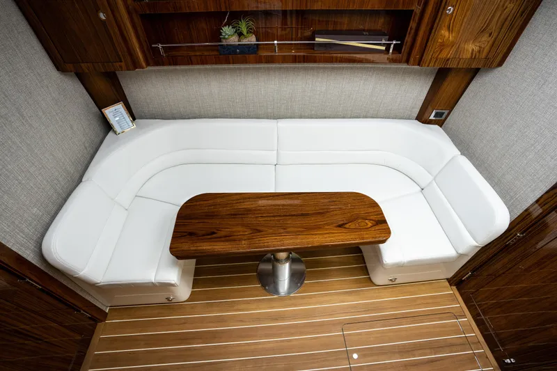 Slide: The Image of Luxurious interior of 2023 HCB 65 Estrella with white seating and wooden table. - 29