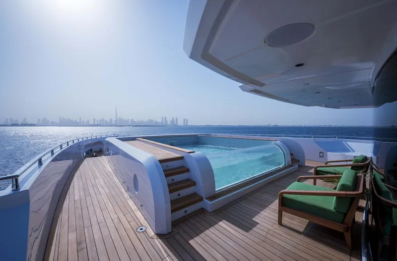 Slide: The Image of Luxurious Majesty 175 yacht deck with pool, overlooking ocean and city skyline, 2026 model. - 16