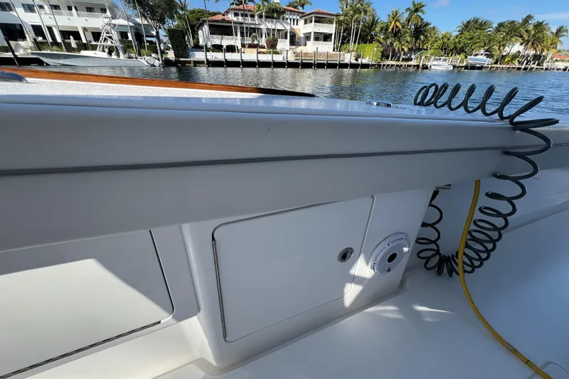Slide: The Image of 2021 Valhalla Boatworks V-41 interior with storage compartment, docked by waterfront homes. - 23
