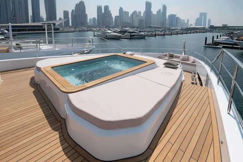 Slide: The Image of Luxurious 2026 Majesty 111 yacht deck with jacuzzi, overlooking marina and city skyline. - 15