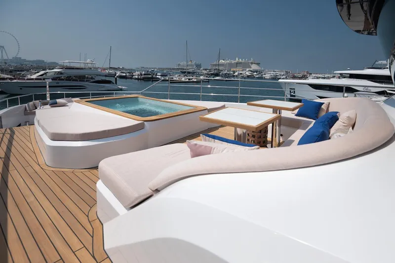 Slide: The Image of Luxurious 2026 Majesty 111 yacht deck with jacuzzi and seating area in marina. - 16