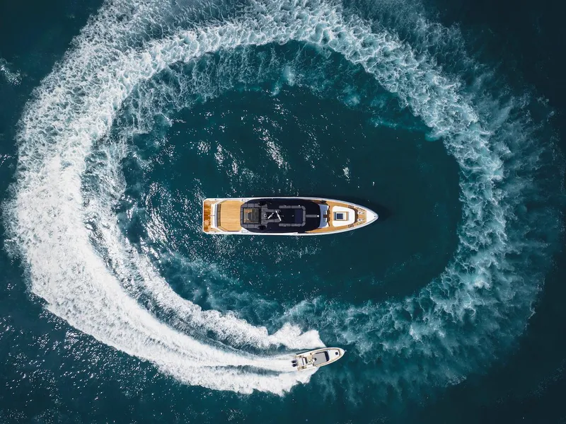 Slide: The Image of Aerial view of 2026 Majesty 111 yacht with speedboat creating circular wake. - 2